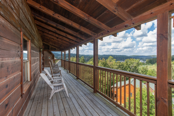 Seating and mountain views from the covered deck at Bear Country, a 3-bedroom cabin rental located in Pigeon Forge