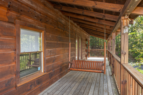 Swing on a covered porch at Bear Country, a 3-bedroom cabin rental located in Pigeon Forge