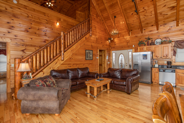 Sofa and two loveseats with kitchen nearby at 5 Star View, a 3 bedroom cabin rental located in Gatlinburg