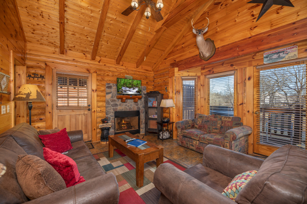 Living room with fireplace, TV, and furniture at Gone Fishin', a 2-bedroom cabin rental located in Pigeon Forge
