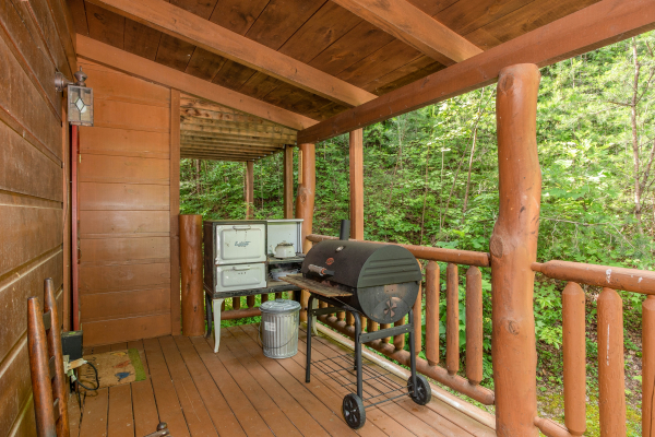 Charcoal grill on a covered deck at Aw Paw's Place, a 1-bedroom cabin rental located in Pigeon Forge
