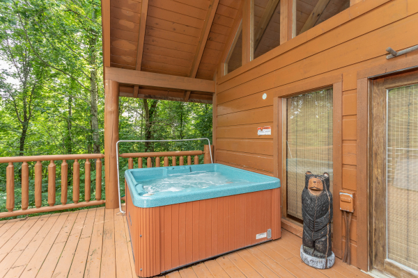 Hot tub on a covered deck at Aw Paw's Place, a 1-bedroom cabin rental located in Pigeon Forge