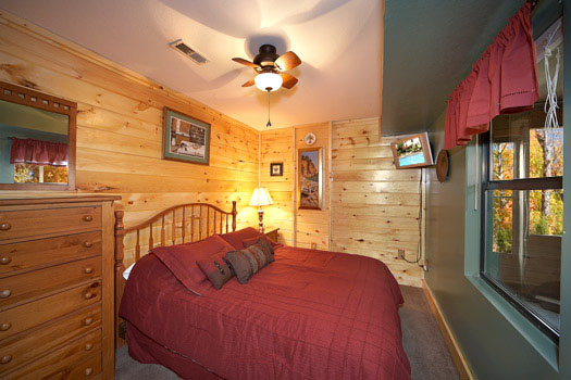 First floor bedroom with queen size bed at Raccoon's Rest, a 2 bedroom cabin rental located in Pigeon Forge