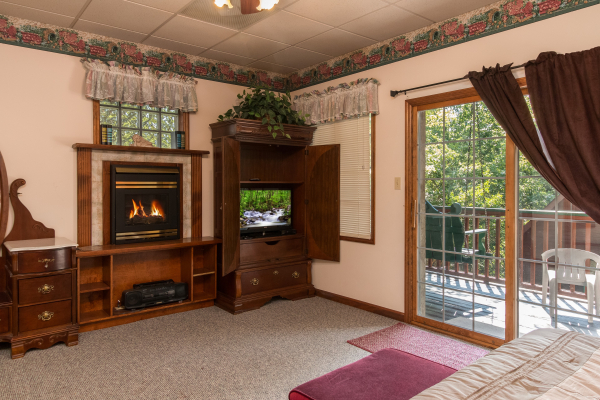Fireplace and TV in a bedroom at Ain't Misbehaven, a 1 bedroom cabin rental located in Pigeon Forge