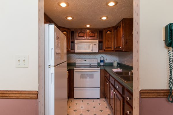 Kitchen with white appliances at Ain't Misbehaven, a 1 bedroom cabin rental located in Pigeon Forge