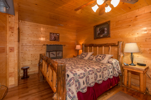 Bedroom with a log bed, night stand, and lamp at Country Bear's Getaway, a 3-bedroom cabin rental located in Gatlinburg