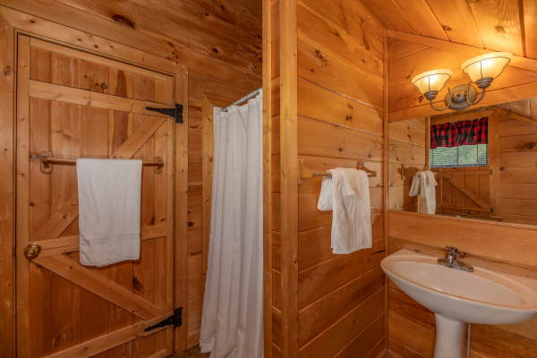 Loft bathroom with a shower and pedestal sink at Away From it All, a 1 bedroom cabin rental located in Pigeon Forge