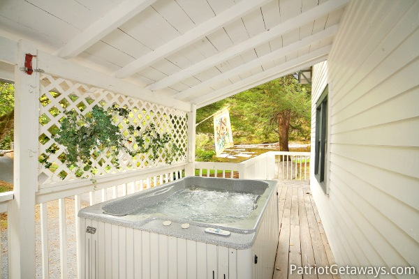 Hot tub on the covered deck at Dolly's Adorable River Cottage, a 3-bedroom cabin rental located in Pigeon Forge