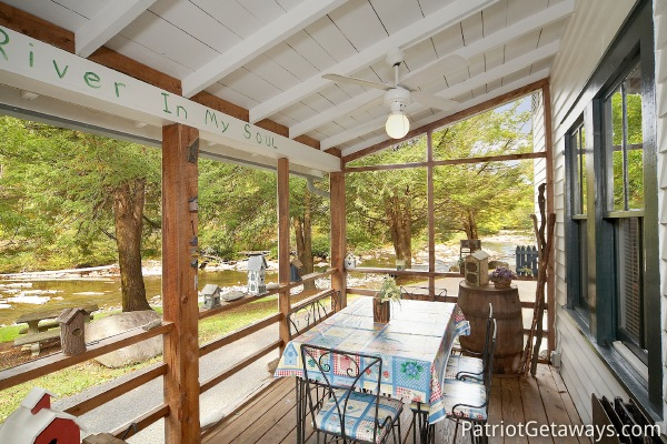 Patio dining on screened deck at Dolly's Adorable River Cottage, a 3-bedroom cabin rental located in Pigeon Forge