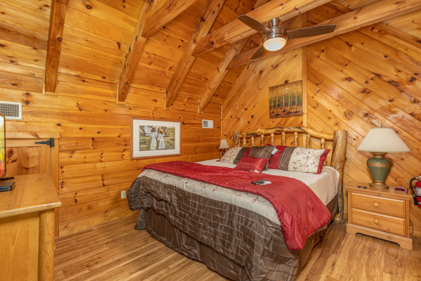 Loft bedroom with a night stand and lamp at Honeymoon in Gatlinburg, a 1 bedroom cabin rental located in Gatlinburg