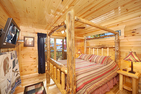 First floor king bedroom with log canopy bed at Natural Wonder, a 4 bedroom cabin rental located in Gatlinburg