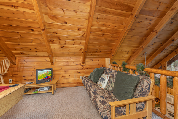 Loft with a futon and TV at A Lover's Secret, a 1 bedroom cabin rental located in Gatlinburg