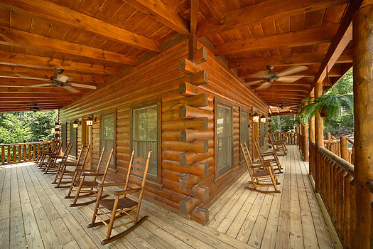 Front and side decks with rocking chairs at Pool House, a 2 bedroom cabin rental located in Gatlinburg