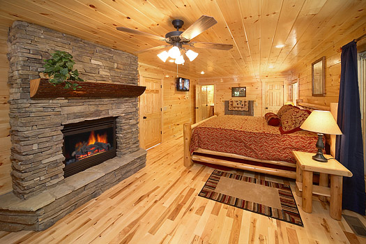 King bedroom with fireplace at Pool House, a 2 bedroom cabin rental located in Gatlinburg