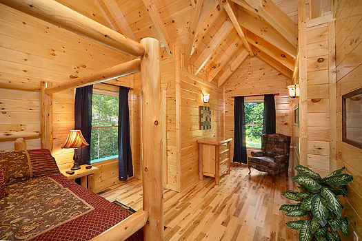 Second level queen bed with sitting area at Pool House, a 2 bedroom cabin rental located in Gatlinburg