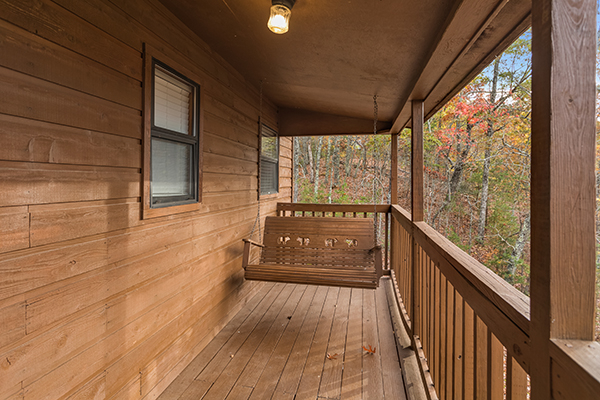 Porch swing on a covered deck at Papa Bear, a 3 bedroom cabin rental located in Pigeon Forge