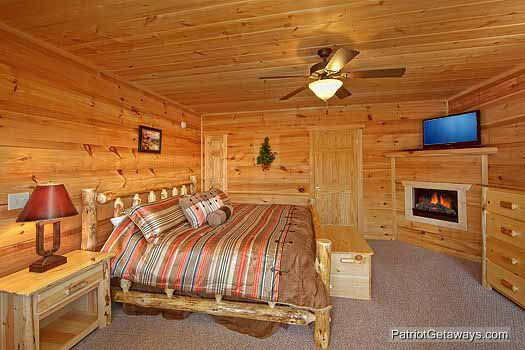 First floor bedroom with king sized bed fireplace tv and attached bathroom with jacuzzi tub at Alpine Pointe, a 5 bedroom cabin rental located in Gatlinburg