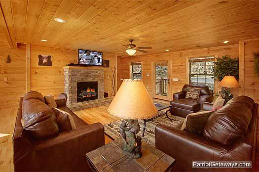A stone fireplace in the living room with large sofas and chair at Alpine Pointe, a 5 bedroom cabin rental located in Gatlinburg