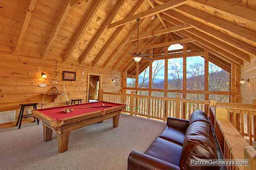 Sofa bed and pool table in lofted game room at Alpine Pointe, a 5 bedroom cabin rental located in Gatlinburg