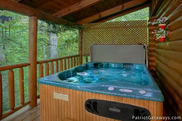 Hot tub under a covered deck of a cabin at A Bear's View, a 1 bedroom cabin rental located in Gatlinburg