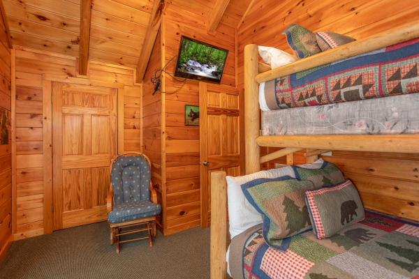 Rocking chair and TV in the bunk room at Mountain Music, a 5 bedroom cabin rental located in Pigeon Forge