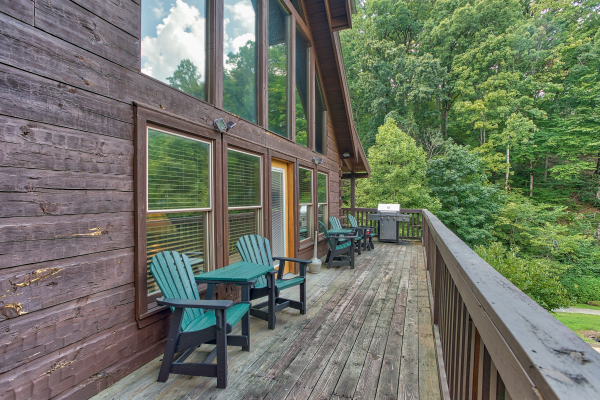 Adirondack chairs and a grill on the deck at Mountain Music, a 5 bedroom cabin rental located in Pigeon Forge