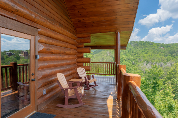 Rocking chairs on a covered deck at God's Country, a 4 bedroom cabin rental located in Pigeon Forge
