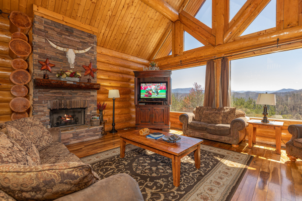 Living room with fireplace, TV, and mountain views at God's Country, a 4 bedroom cabin rental located in Pigeon Forge
