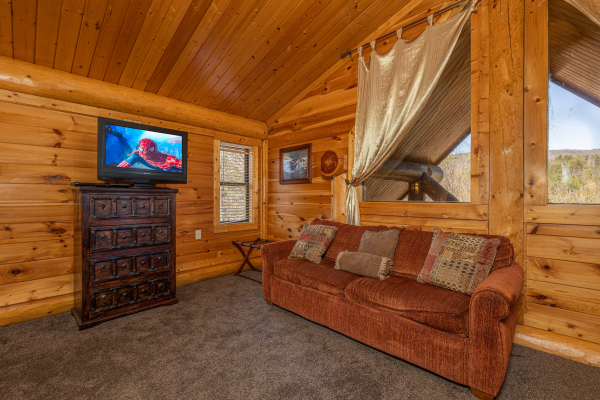 Sofa, dresser, and TV at God's Country, a 4 bedroom cabin rental located in Pigeon Forge