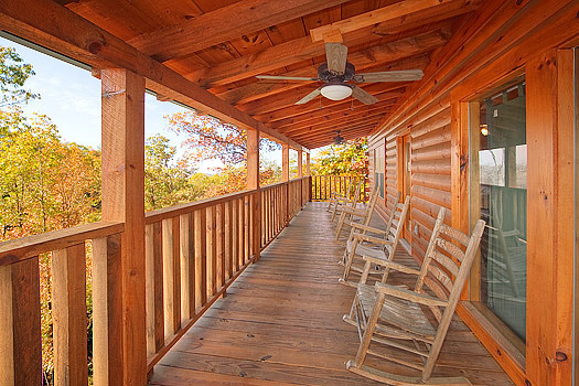 Rockers on a covered deck at Hickernut Lodge, a 5-bedroom cabin rental located in Pigeon Forge