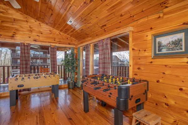 Two foosball tables in the loft at Hickernut Lodge, a 5-bedroom cabin rental located in Pigeon Forge