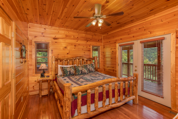 Bedroom with a log bed and deck access at Four Seasons Lodge, a 3-bedroom cabin rental located in Pigeon Forge