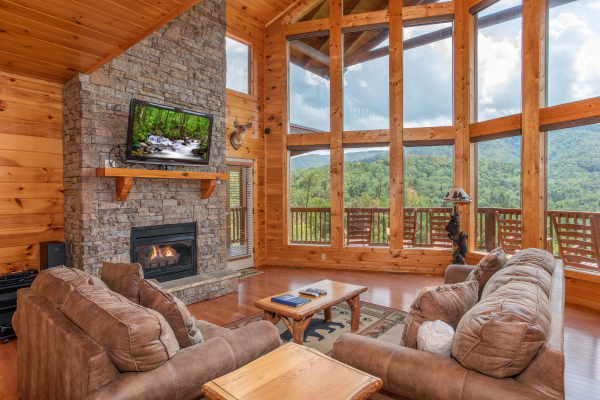 Vaulted ceilings with floor-to-ceiling windows, fireplace, and TV at Four Seasons Lodge, a 3-bedroom cabin rental located in Pigeon Forge